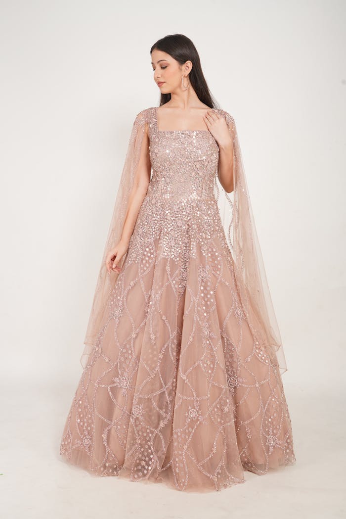 about-us A stylish woman in a glittering gown poses in a studio setting.