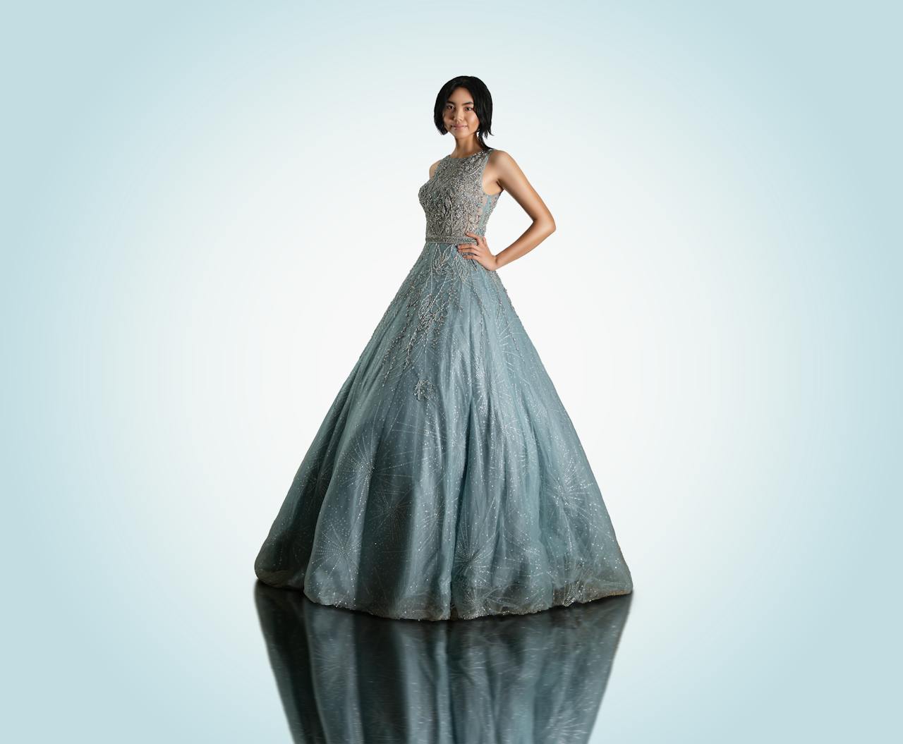 home-hero Asian woman elegantly posing in a blue ball gown with a hand on her waist.